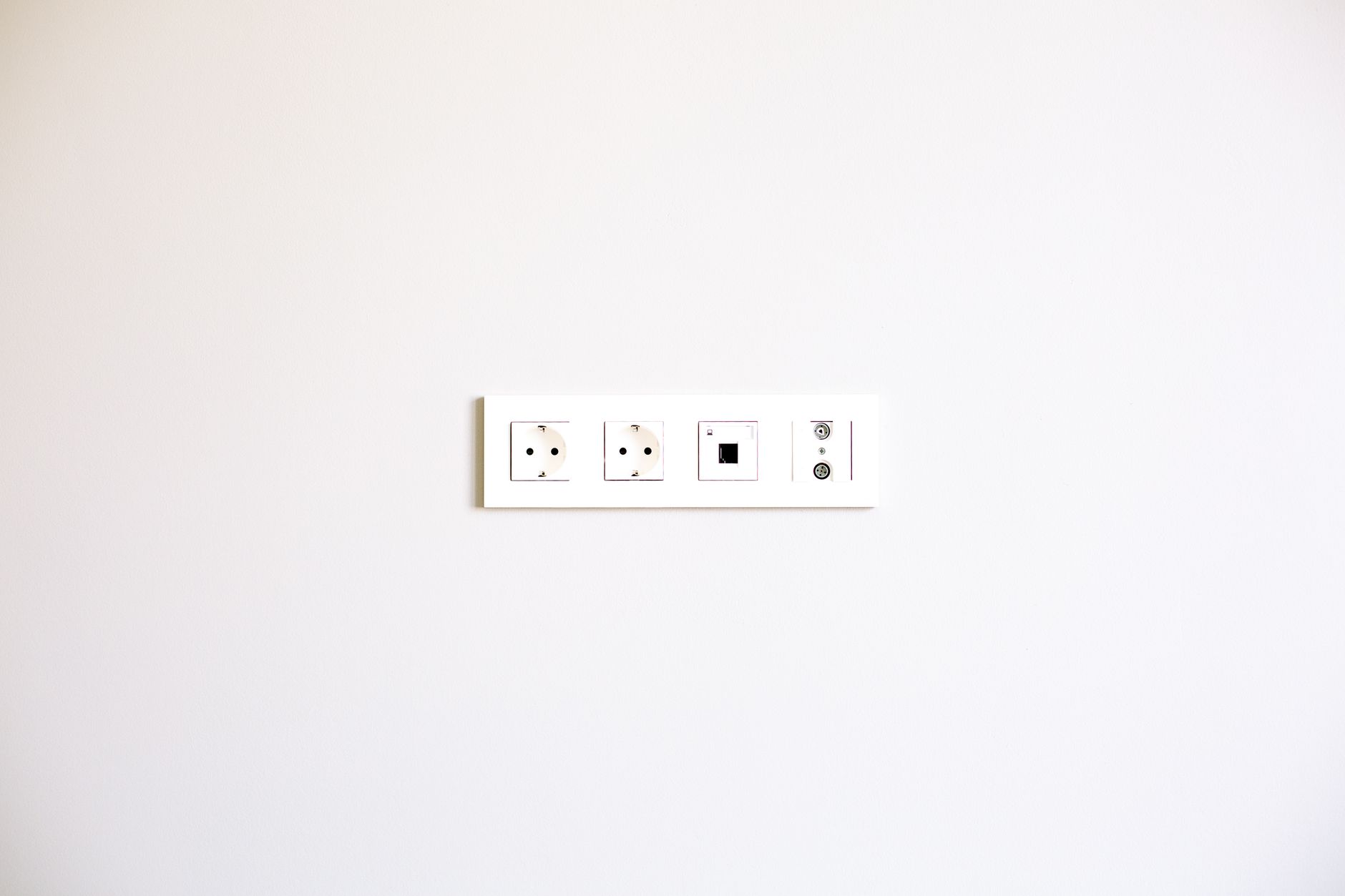A minimalist image showcasing a modern wall outlet array on a bright white wall.