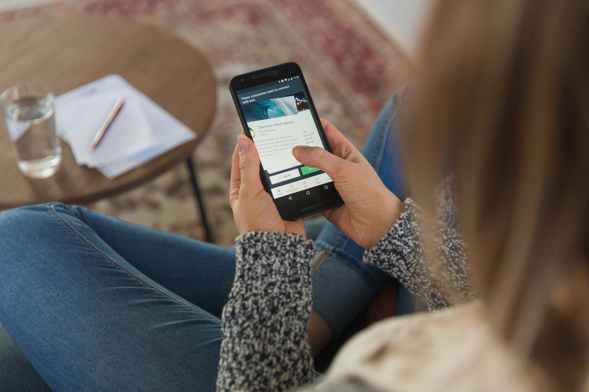 Close-up of woman using smartphone indoors, focused on a mobile app.