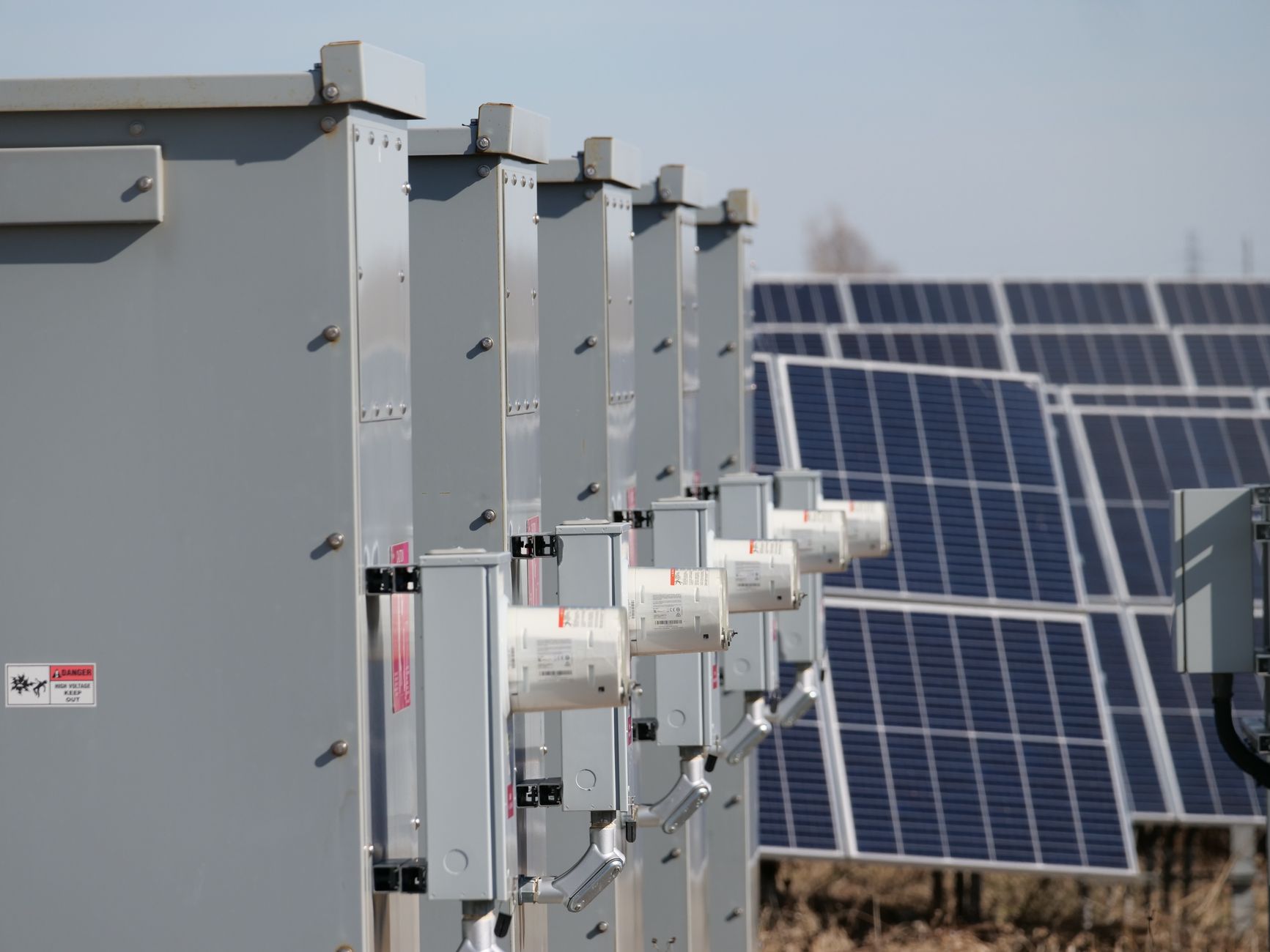 Close-up of electrical boxes and solar panels harnessing solar energy outdoors.