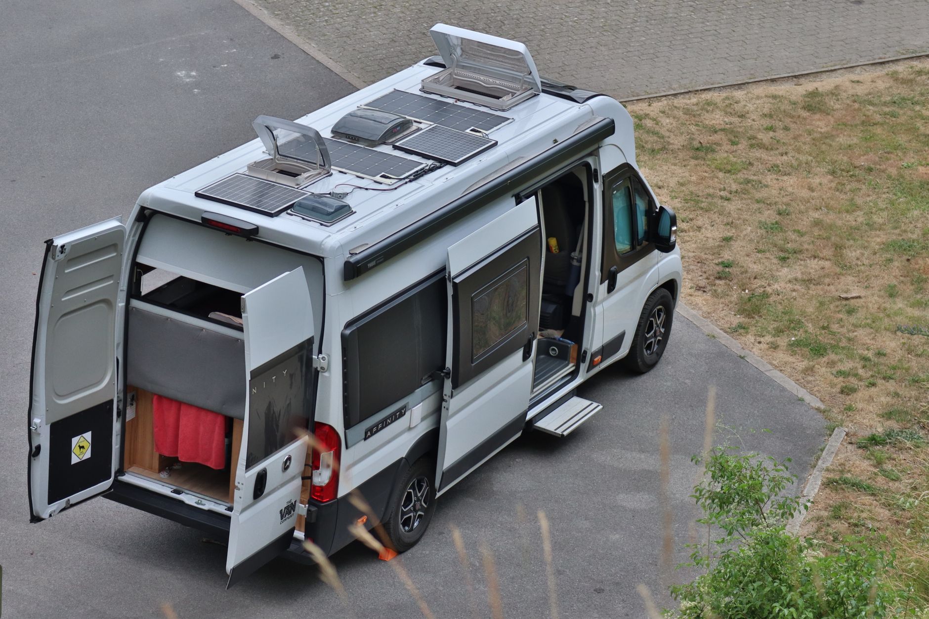 Top view of a campervan parked outdoors with solar panels, symbolizing vanlife in Bouillon, Belgium.