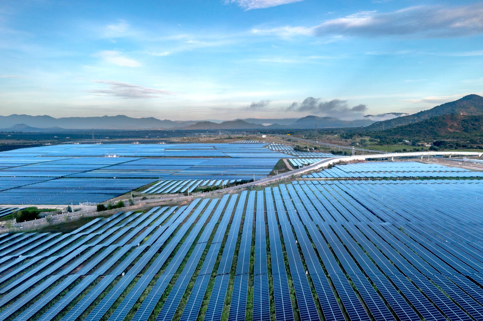 Aerial view of a vast solar farm in Vietnam, showcasing sustainable energy solutions at sunrise.