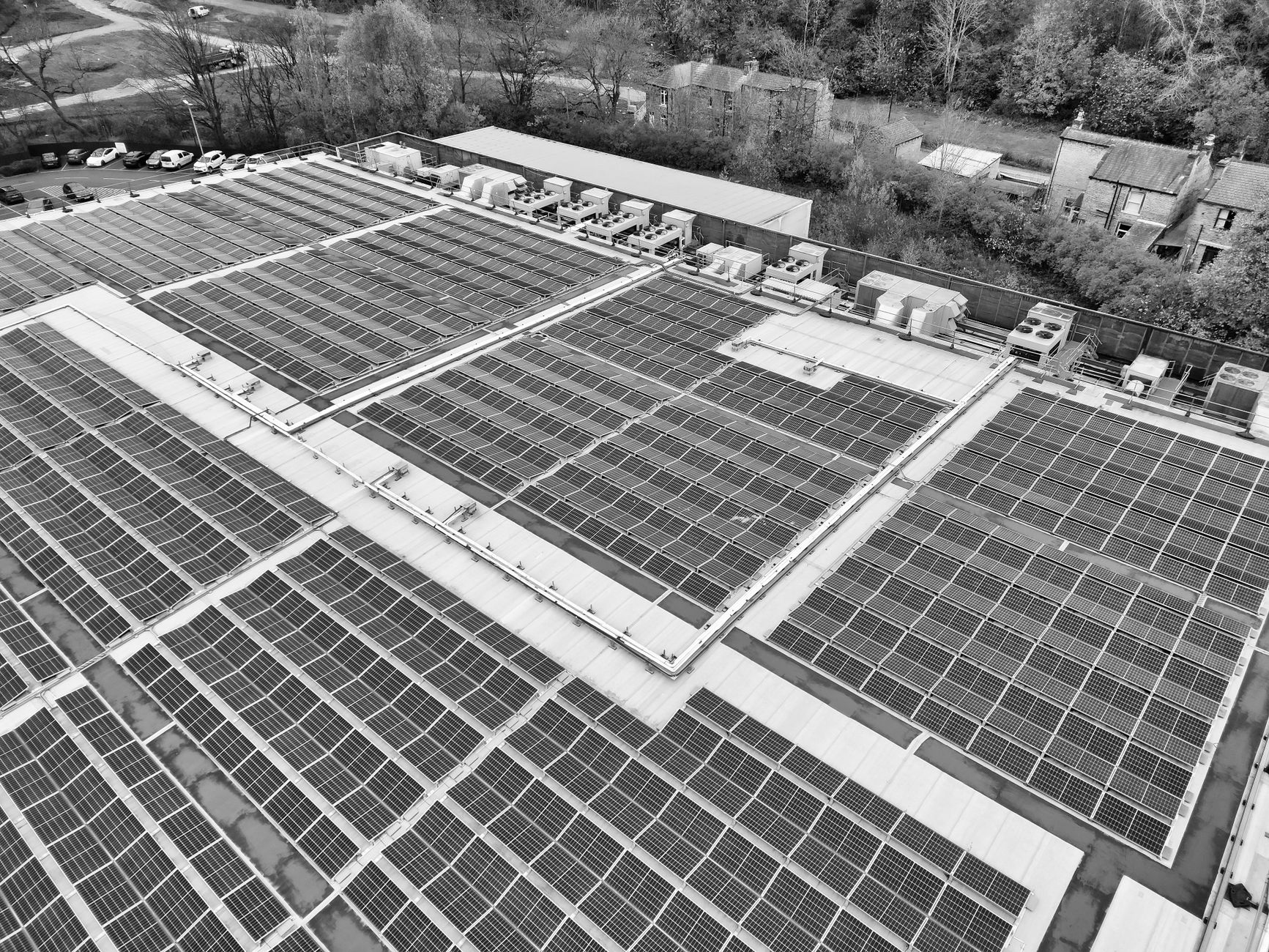 A wide aerial shot of solar panels on industrial buildings, promoting renewable energy.